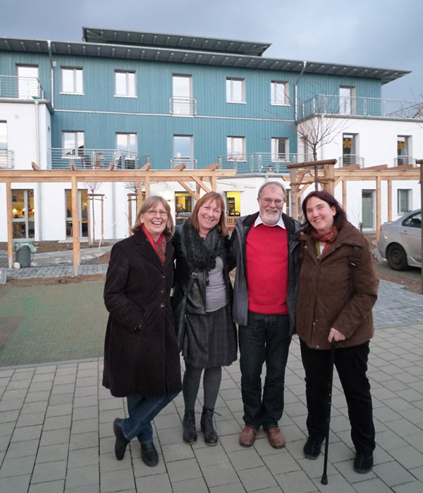 Vier Personen - drei Frauen und ein Mann - stehen vor einem blau-weißen Neubau. Die Personen sind: Doro Corts, Georg Geist, Uta Kallenbach und Elisabeth Sprenger